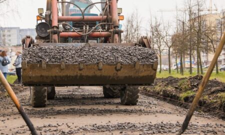 Экскаватор работает на строительстве дороги.