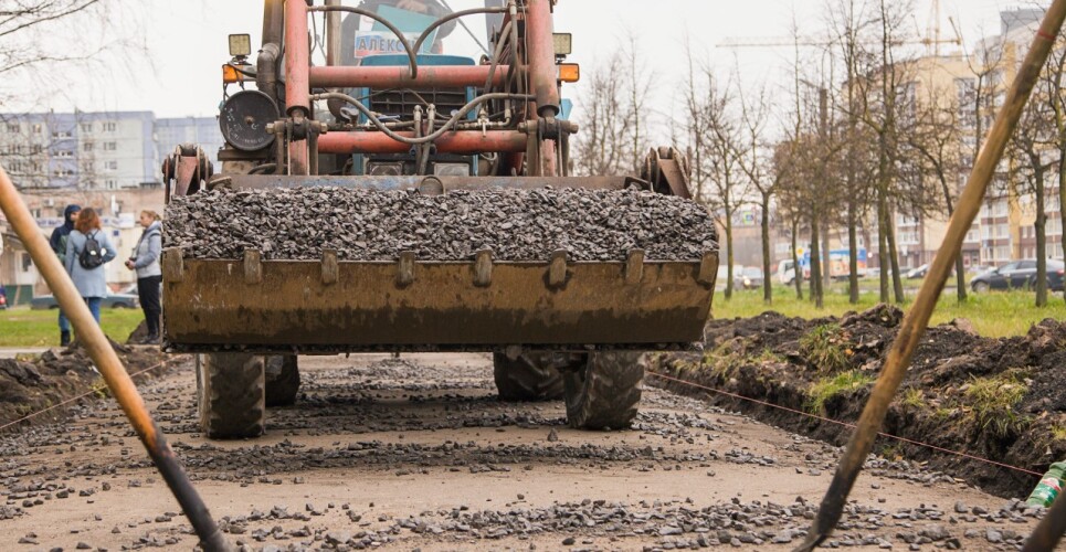 Экскаватор работает на строительстве дороги.