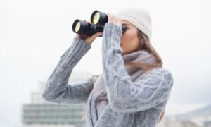 alt девушка в свитере с биноклем