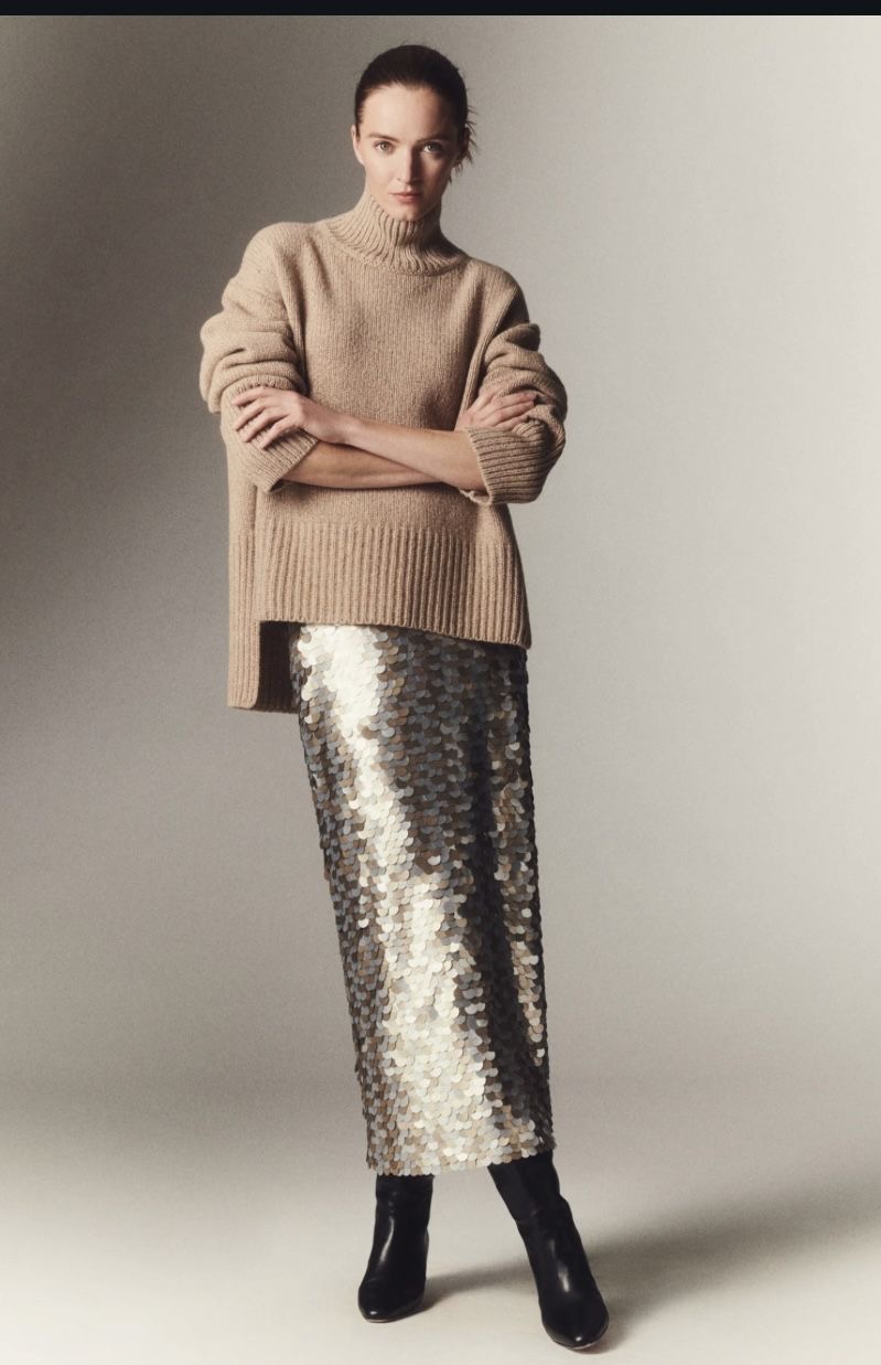 Девушка в вязаном свитере и блестящей юбке