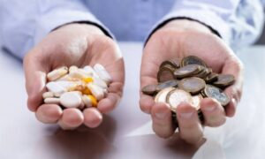 Таблетки и деньги в руках у человека
