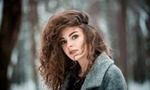 Девушка с кудрявыми волосами в лесу