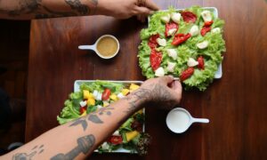 Человек с двумя тарелками салата и кофе