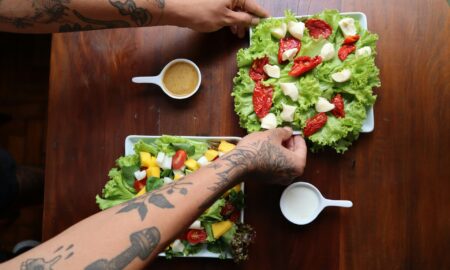 Человек с двумя тарелками салата и кофе