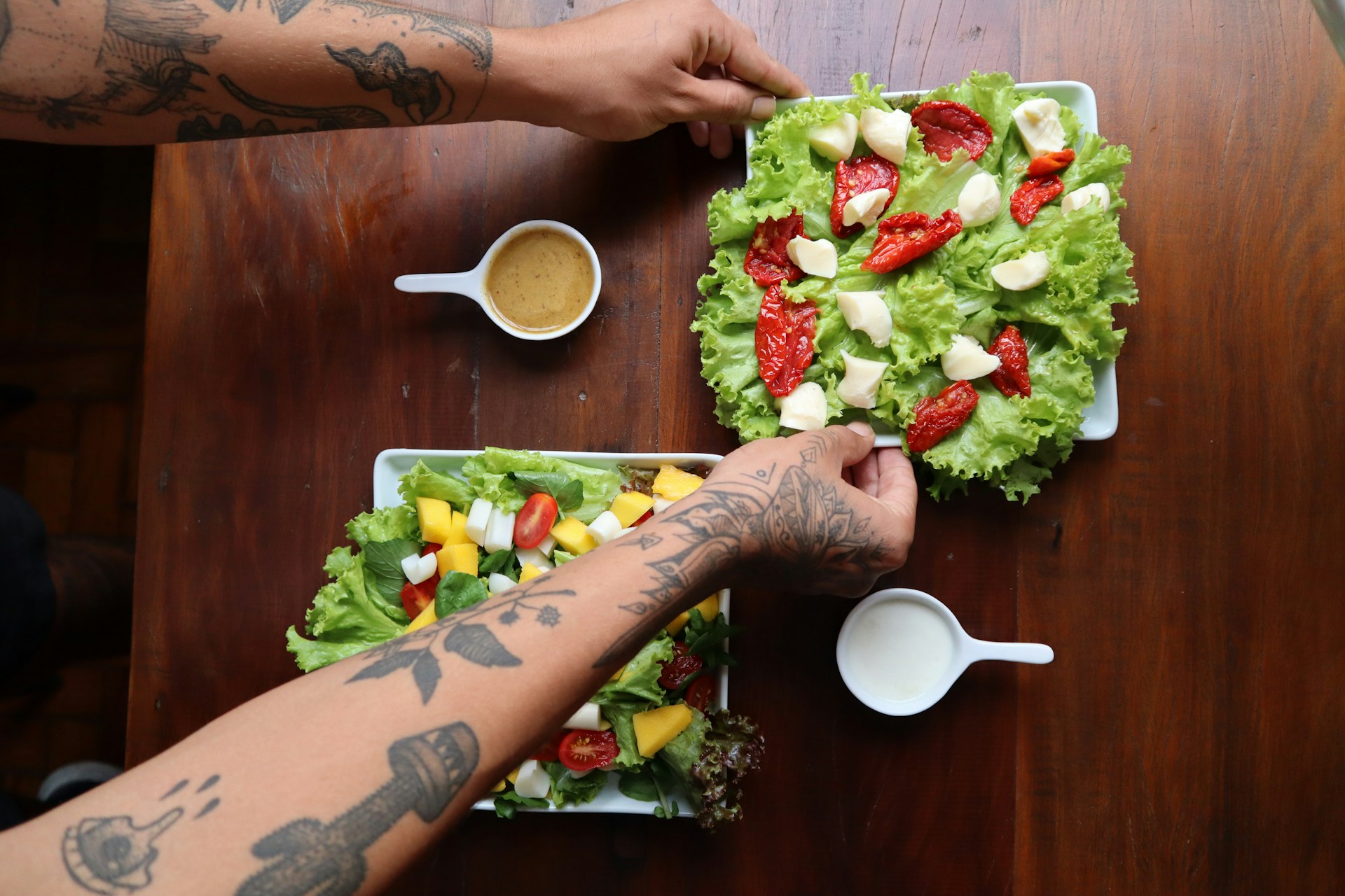 Человек с двумя тарелками салата и кофе