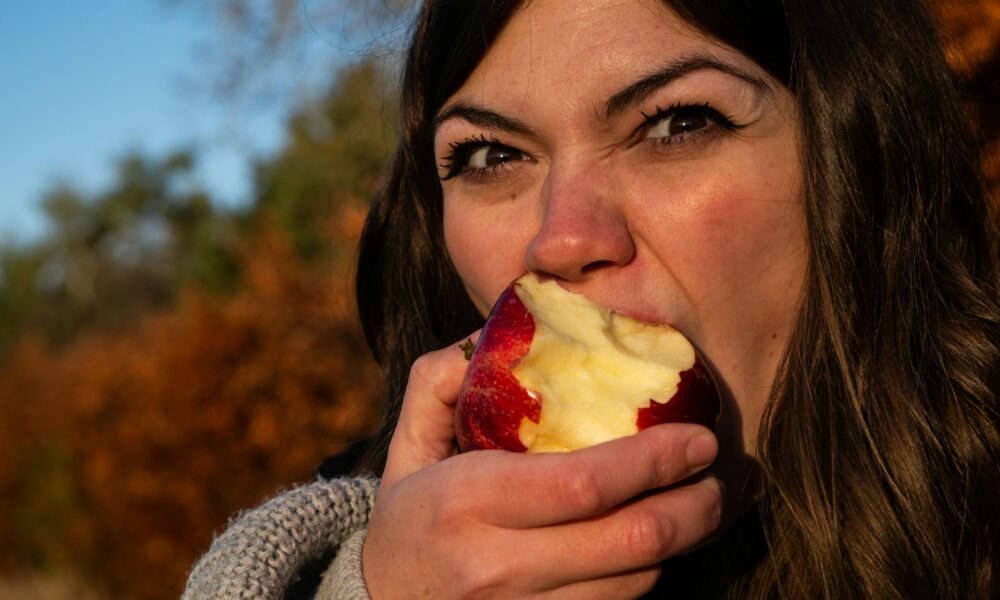 Женщина ест яблоко