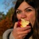 Женщина ест яблоко