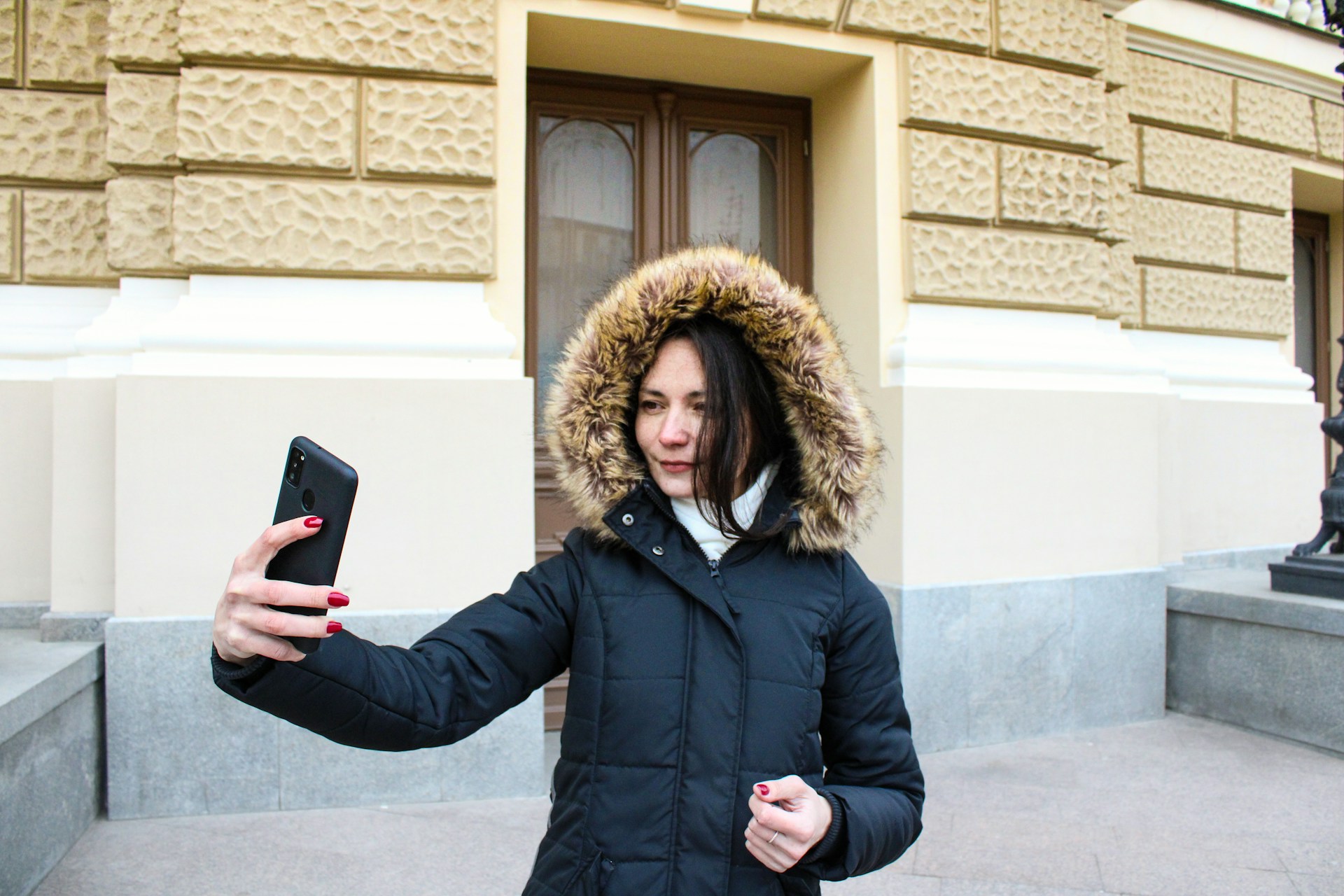 Alt девушка в пуховике делает селфи
