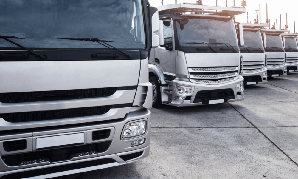 Крупные грузовые автомобили стоят перед выездом на дорогу