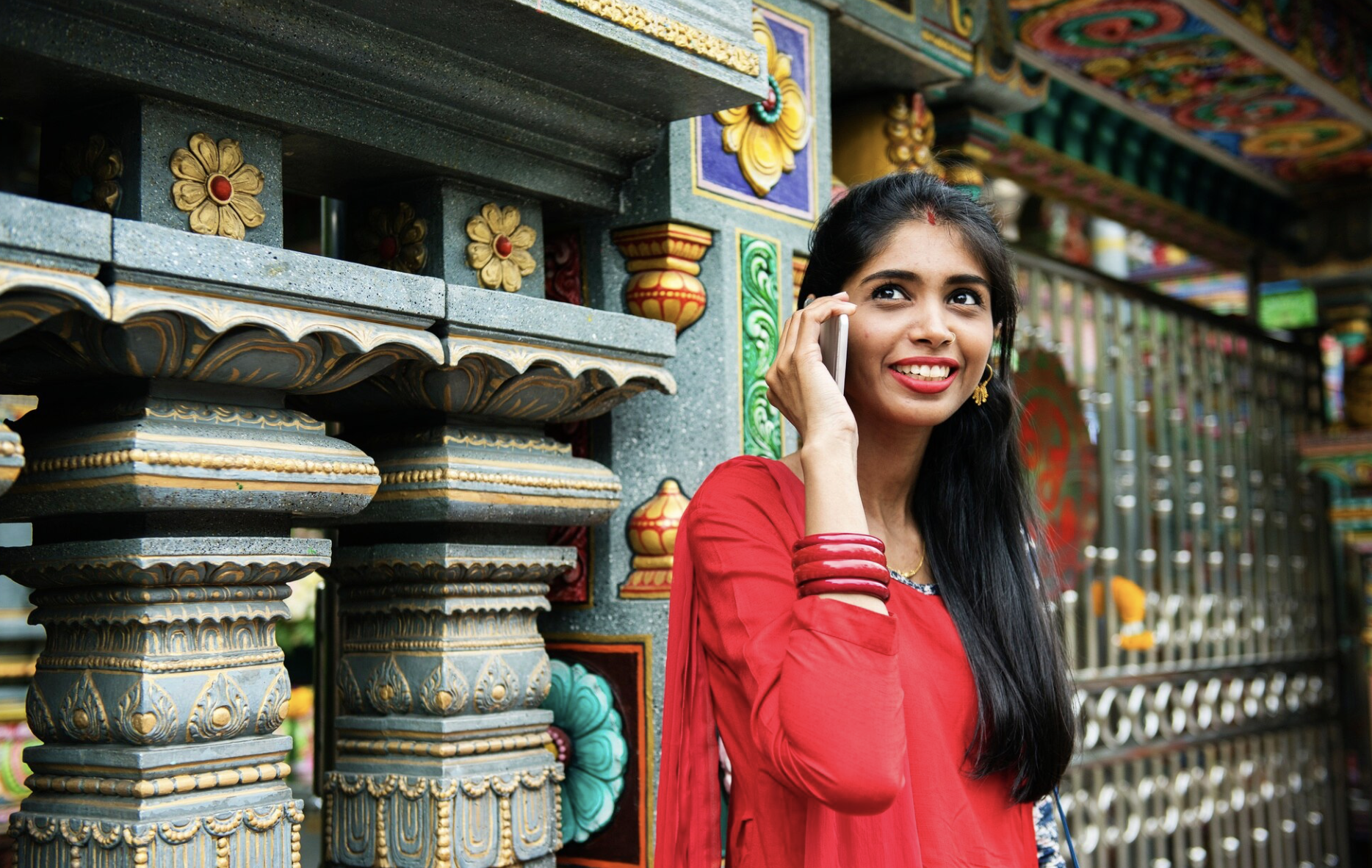 Девушка в Индии в национальном сари разговаривает по телефону