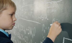 Мальчик пишет на доске