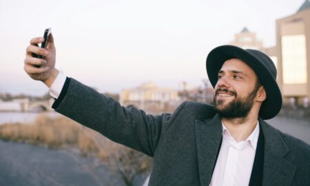 Мужчина фотографирует себя на телефон