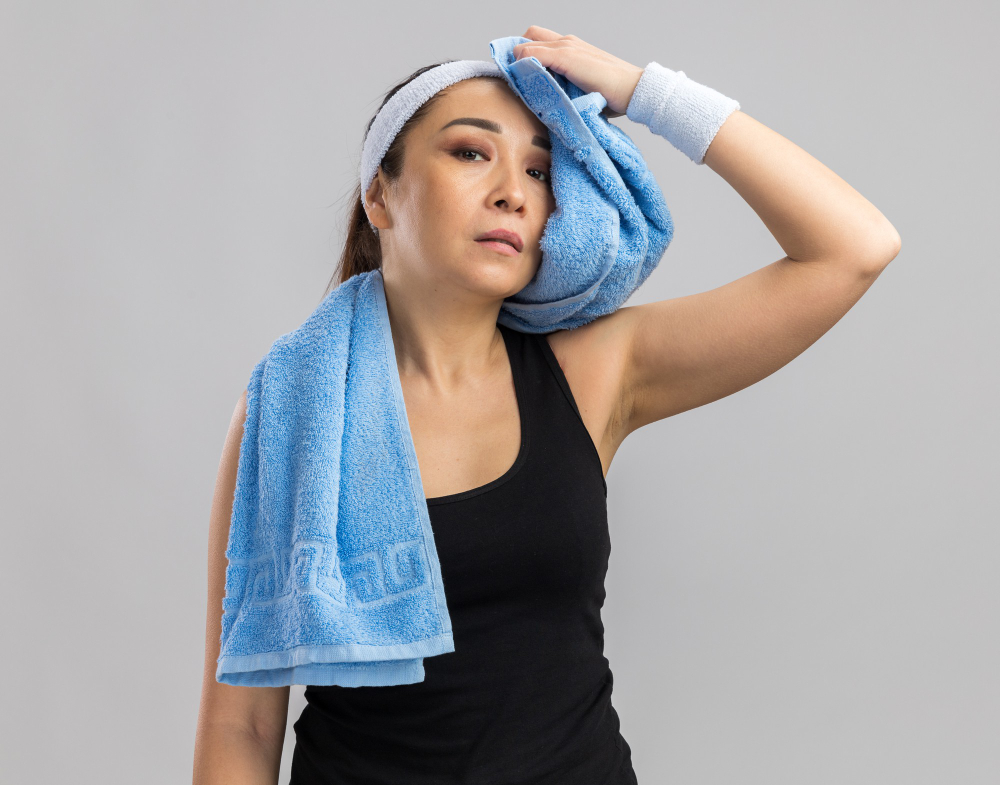 Спортсменка вытирает пот полотенцем