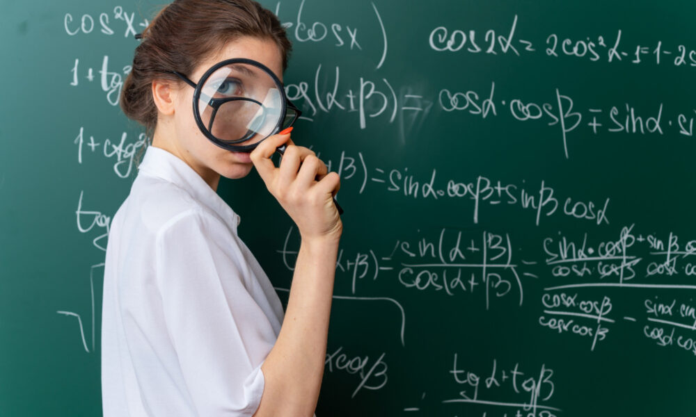 Девушка с лупой у доски