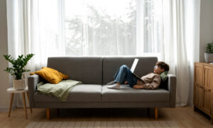 Ребёнок лежит на диване с компьютером