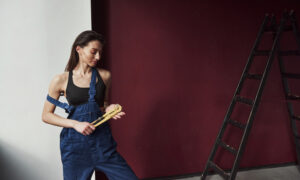 Девушка красит стену в винный цвет