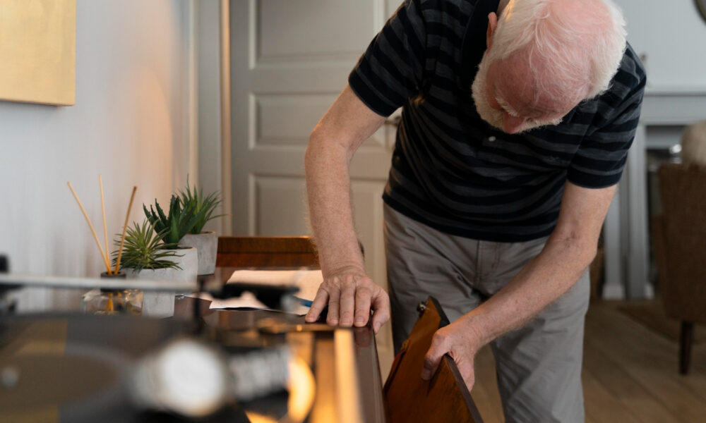 седой старик заглядывает в комод