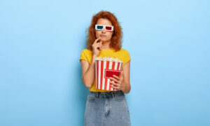 девушка с попкорном смотрит кино