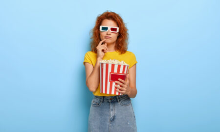 девушка с попкорном смотрит кино