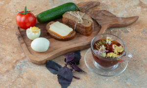 Яйцо, хлеб, огурец, помидор и ромашковый чай на столе