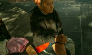 Бабушка сидит на скамейке