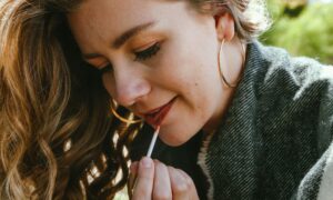 Девушка красит губы