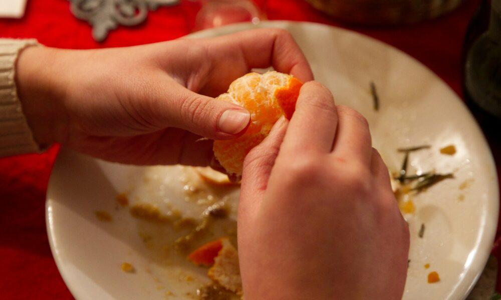 Чистит мандарины