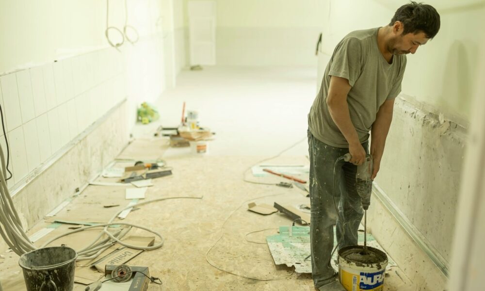 Человек ремонтирует стены