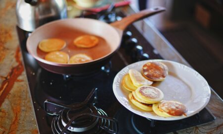 Жарит оладьи на сковороде