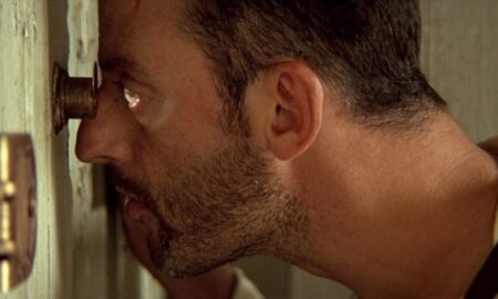 Актёр Жан Рено смотрит в дверной глазок