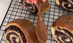 кулинар покрывает булочки шоколадом