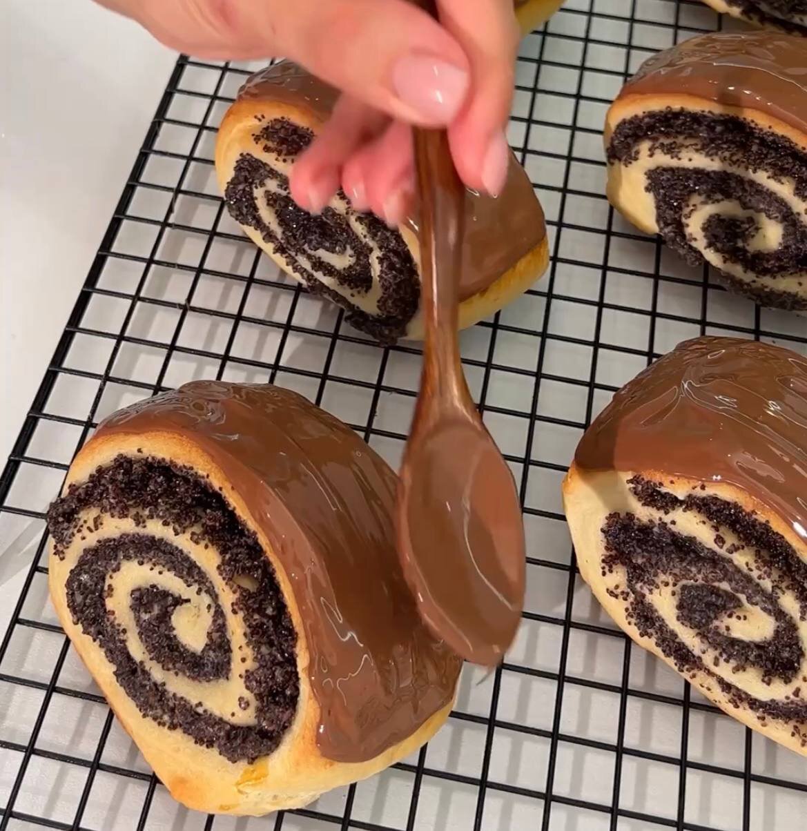 кулинар покрывает булочки шоколадом