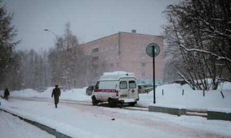 скорая помощь едет по заснеженной дороге