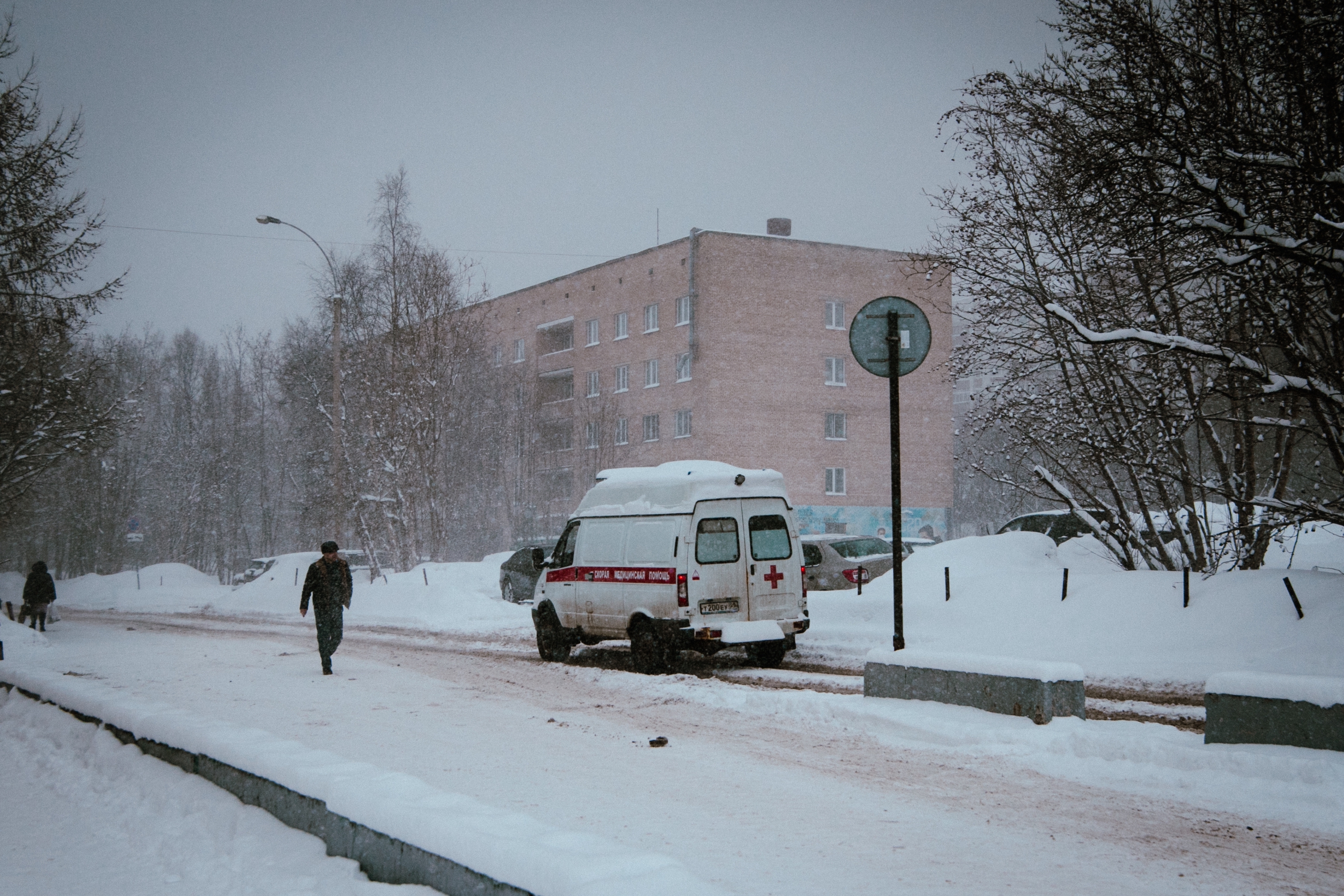 скорая помощь едет по заснеженной дороге