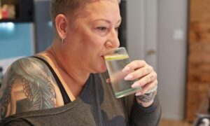 Женщина пьет воду с лимоном