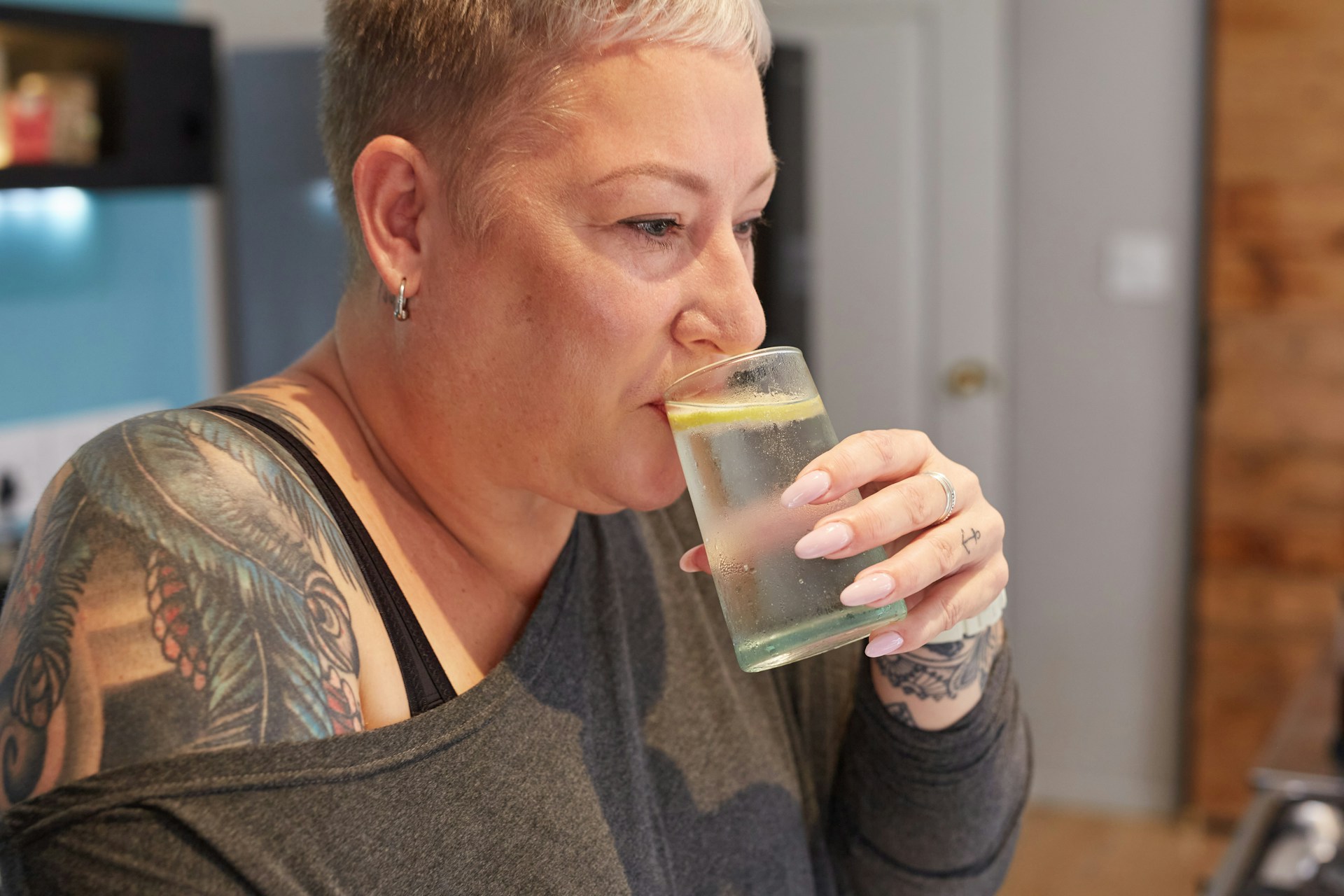 Женщина пьет воду с лимоном