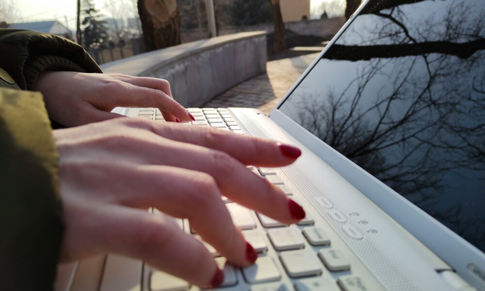 Девушка печатает на ноутбуке