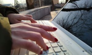 Девушка печатает на ноутбуке