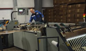 мужчина работает на станке на заводе