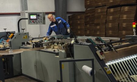 мужчина работает на станке на заводе