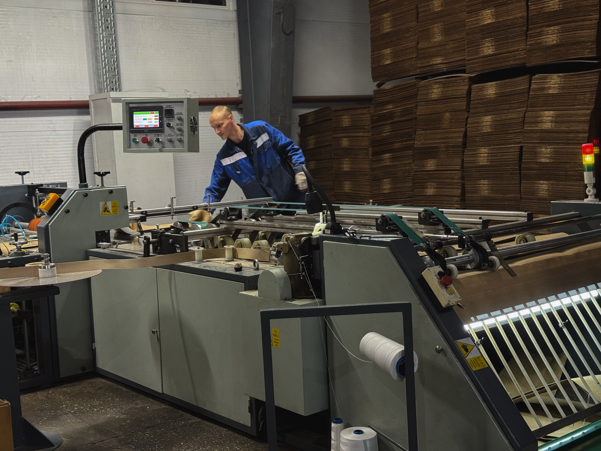 мужчина работает на станке на заводе