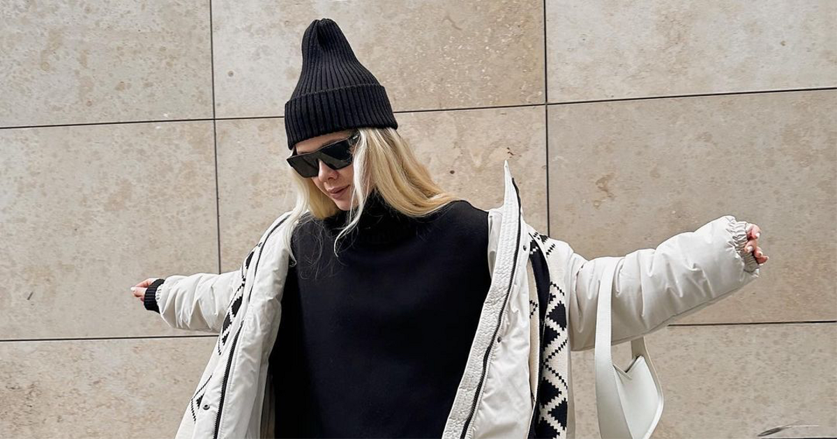 Женщина в чёрной шапке и пуховике