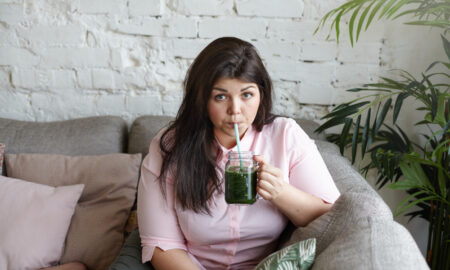 Девушка с лишним весом пьёт смузи