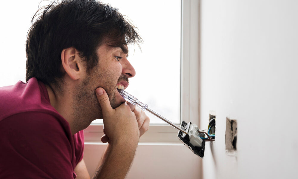 Электрик чинит розетку