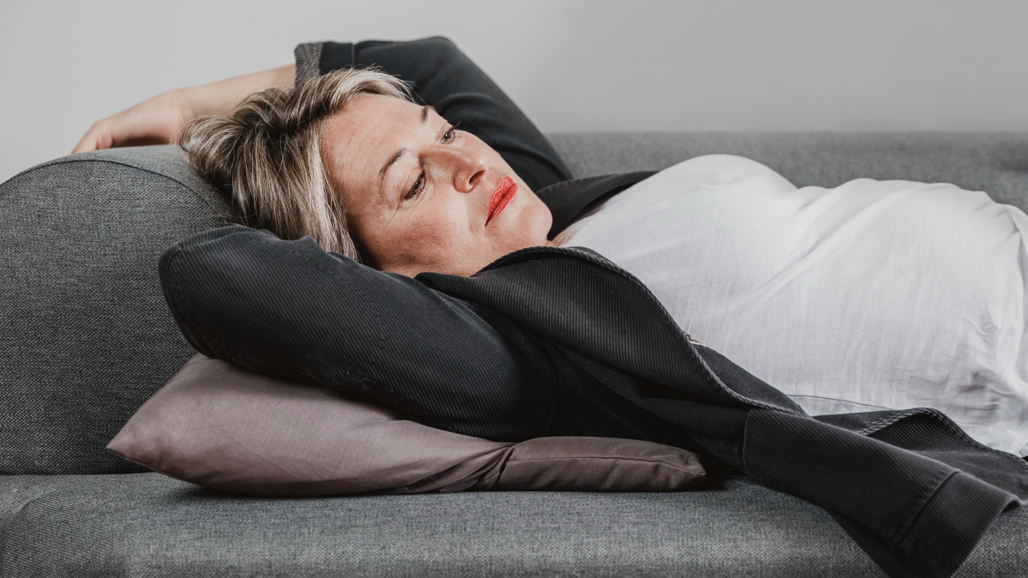 Уставшая женщина спит на диване