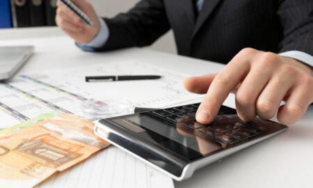 рука мужчины в костюме, калькулятор, деньги