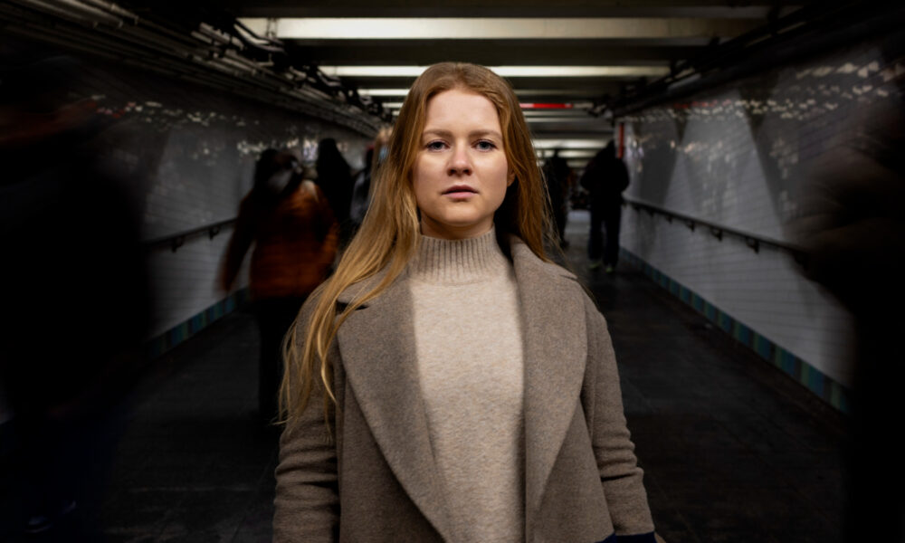 Женщина позирует во время поездки в городском метро