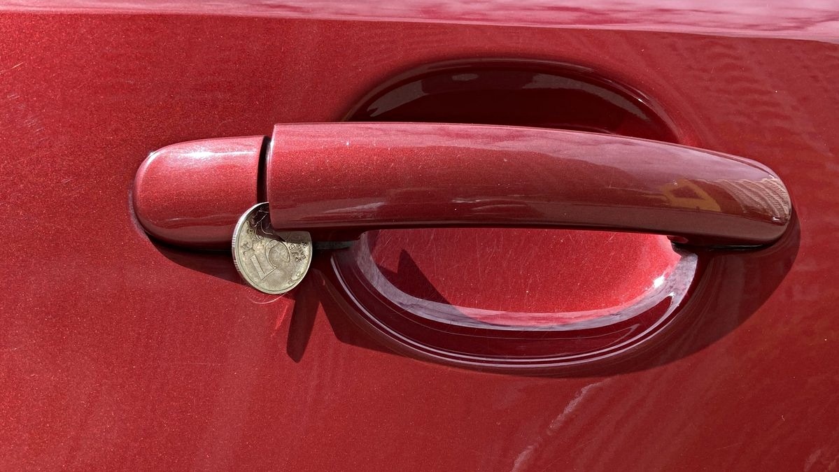 монета в ручке автомобиля