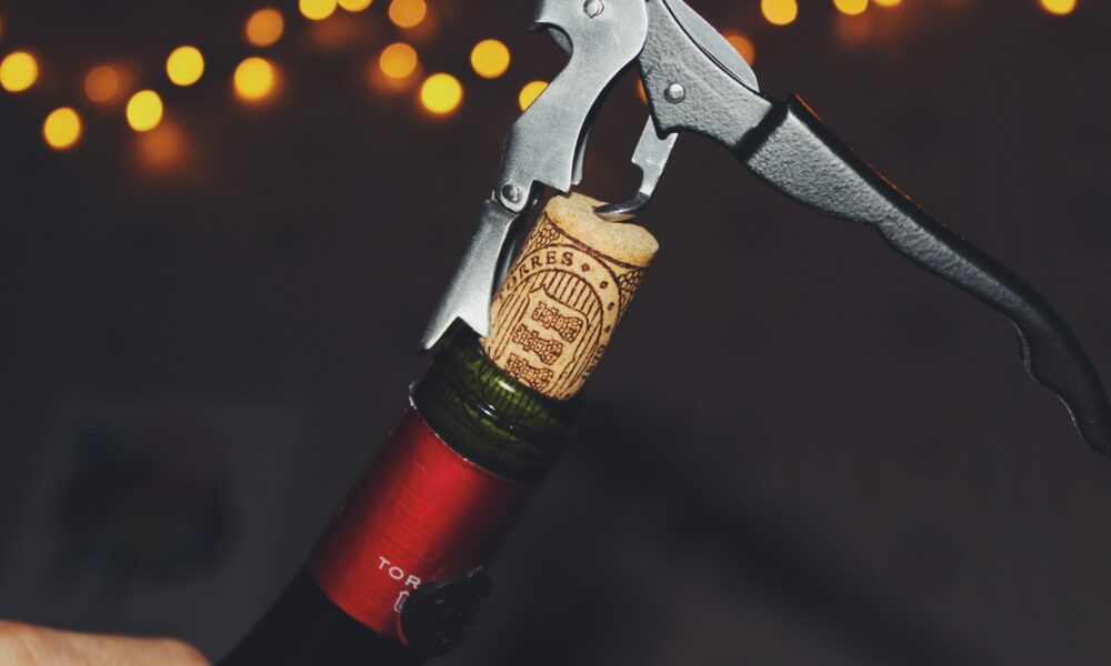 Открывает вино