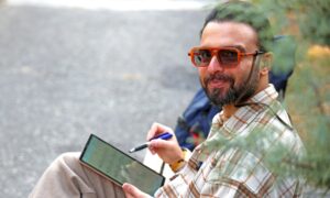 Мужчина со смартфоном на скамейке